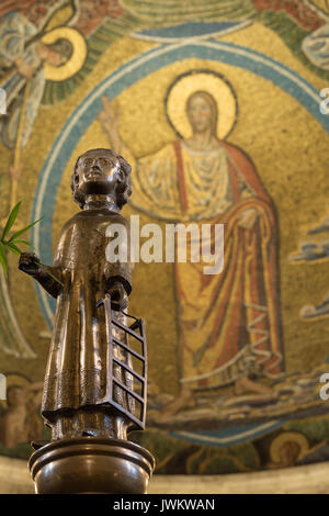 Saint-laurent sur un pilier de bronze dans la cathédrale de Lund, tenant un gril et le Christ dans l'arrière-plan. Lund, Suède, le 10 août 2017 Banque D'Images