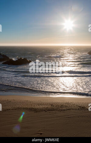 Coucher de soleil sur la plage de sable lisse avec des roches dans l'Océan Banque D'Images