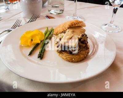 Un délicieux apéritif d'asperges, champignons, foie gras sur une assiette blanche sur une table Banque D'Images