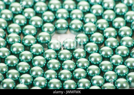 Une chaîne de perles de couleur turquoise sur une surface blanche Banque D'Images