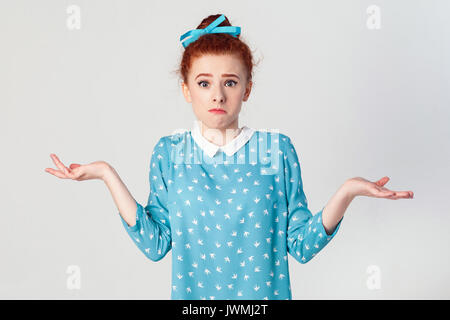 Des émotions négatives, les expressions du visage, perception et l'attitude de la vie. Perplexe jeune rousse fille avec les bras, haussant les épaules, disant : Banque D'Images