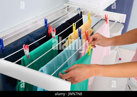 Close-up of Woman Hanging chiffon propre humide sur corde à linge dans la buanderie Banque D'Images