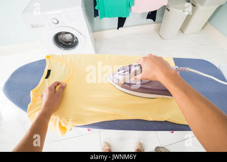 Vue perspective de POV Woman Ironing Clothes sur planche à repasser à la maison Banque D'Images