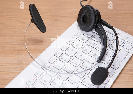 Casque avec microphone blanc couché sur un clavier d'ordinateur pour une communication d'entreprise et contact concept vue close up d'en haut Banque D'Images