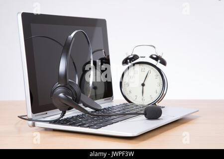 Réveil debout sur 24 par casque sur clavier d'ordinateur portable Banque D'Images