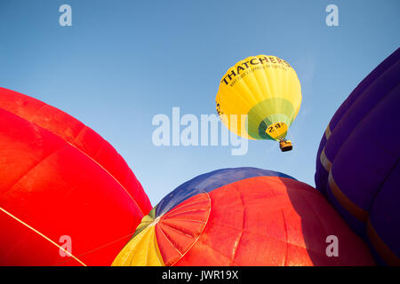 Montgolfières décoller de la base de lancement pendant l'ascension de masse, où des ballons de tous les coins du monde se rassemblent à Ashton Cour, Bristol, à prendre part à la Bristol International Balloon Fiesta. Banque D'Images