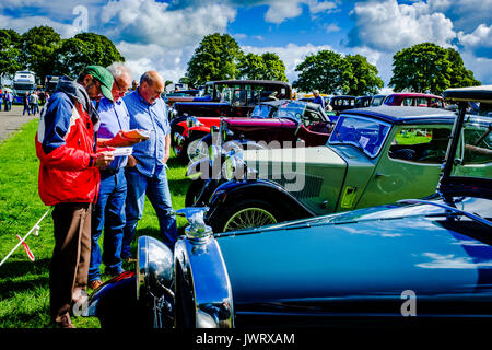 Biggar, South Lanarkshire - 44e rallye de véhicules anciens. Trois hommes admirer les voitures classiques. Banque D'Images