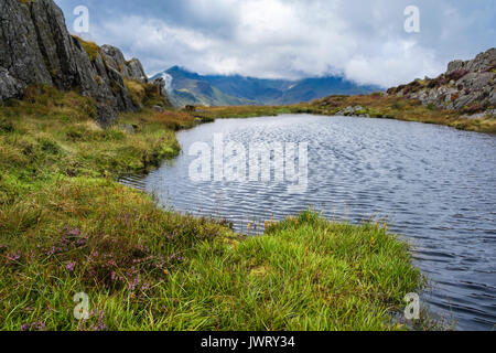 La recherche à travers les hautes terres sur la piscine à Cribau Carnedd y Snowdon horseshoe dans les nuages bas au-delà de montagnes de Snowdonia National Park. Pays de Galles, Royaume-Uni Banque D'Images