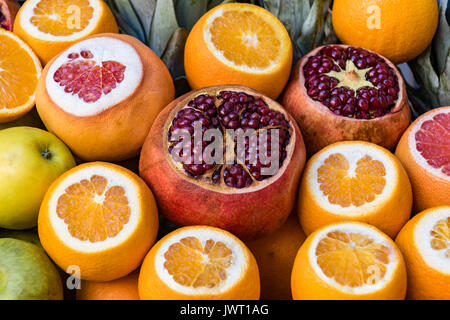 Les oranges, grenades, pamplemousse tranchée sur le marché de l'affichage à Banque D'Images