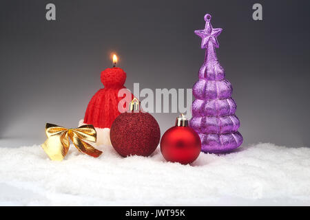 Noël Décoration de Noël, bow, bougie allumée et toy sapin à neige, carte conceptuelle sur fond gris Banque D'Images