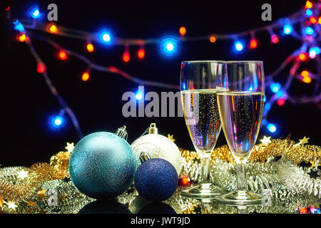 Deux verres de champagne et nouvel an noël décoration plus de boules de lumières fond flou garland rougeoyant Banque D'Images