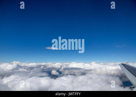 Vue latérale de cumulus sur l'Europe centrale de l'avion en descente. Le tiers inférieur des nuages de ce plan horizontal. Ciel bleu profond au-dessus. Banque D'Images