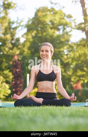 Jeune femme pratiquant le yoga en plein air au parc Banque D'Images