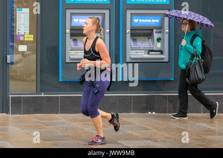 Preston, Lancashire. 14 août 2017. Météo britannique. Début des pluies à la journée dans le centre-ville, les usagers arrivent pour travailler dans le quartier central des affaires. Météo britannique humide a des effets dévastateurs sur le revenu de la vente au détail avec de nombreux magasins de vente d'été prolongée en cours d'exécution. L'Office National des Statistiques a déjà dit que les conditions météorologiques ont un impact important sur l'économie britannique dans son ensemble, avec des périodes d'unseasonal susceptible de faire des ravages sur le commerce de détail. /AlamyLiveNews MediaWorldImages ; crédit. Banque D'Images