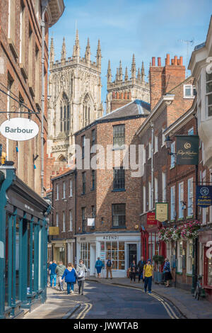 Les touristes la marche sur une rue médiévale Petergate élevé dans le centre de York vers la cathédrale Banque D'Images