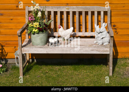 Les jonquilles (Narcissus), jacinthes (hyacinthus), primevères (Primula) et violette (Viola) sur un banc de jardin avec décoration de printemps Banque D'Images