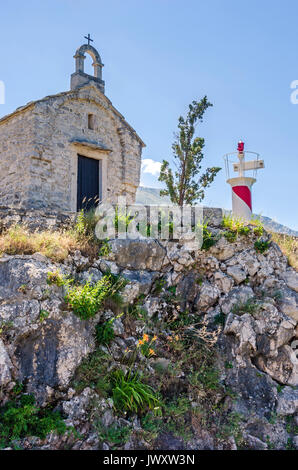 Une petite vieille chapelle et une tour d'éclairage de l'Institut de Biologie Marine à Kotor, Monténégro Banque D'Images