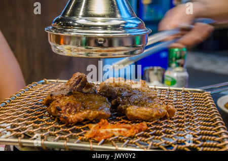 La cuisson de la viande sur un barbecue coréen Koream dans un restaurant. Le repas est préparé sur le grill sur la table devant les invités, Banque D'Images