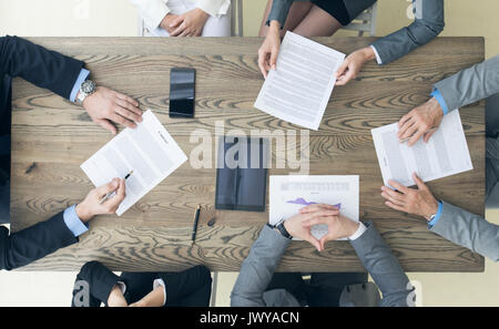 Les gens d'affaires contrat discuter assis autour de la table de bureau, vue du dessus Banque D'Images