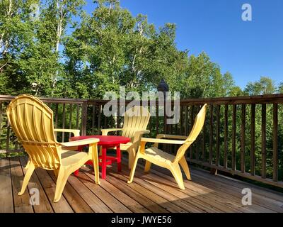 Chaises adirondack jaune sur une terrasse en été Banque D'Images