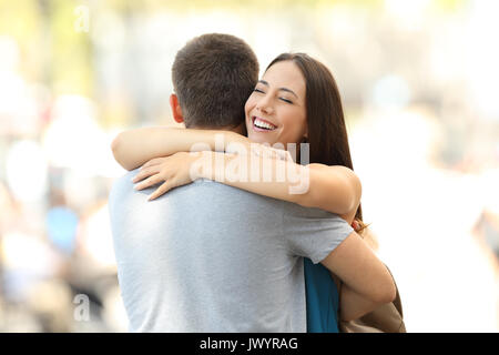 Happy girlfriend hugging son partenaire après la rencontre dans la rue Banque D'Images