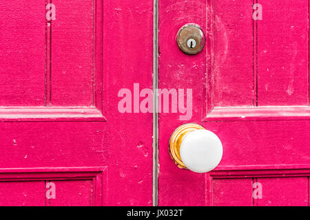 Gros plan du bouton de porte blanc et rouge, magenta poignée porte en bois peint Banque D'Images