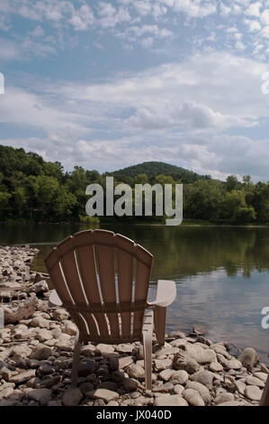 Une chaire sur la rive du fleuve sous un ciel ensoleillé lumineux Banque D'Images