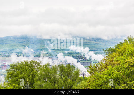 La fumée ou de la vapeur industrielle au cours de brouillard brouillard nuageux et les montagnes au-dessus de la ville, Québec City Banque D'Images