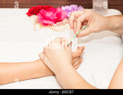 L'esthéticienne polish les ongles de la cliente avant de mettre du vernis à ongles Banque D'Images