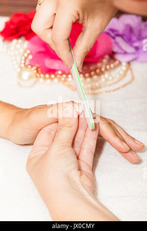 L'esthéticienne polish les ongles de la cliente avant de mettre du vernis à ongles Banque D'Images