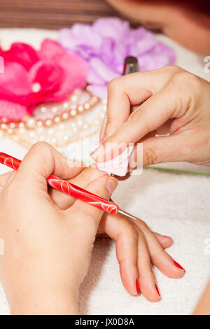 L'esthéticienne élimine l'ancien vernis à ongle avec un coton et de suppression Banque D'Images