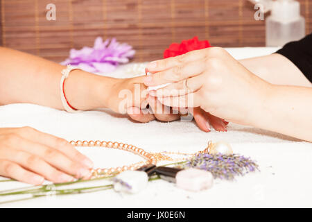 L'esthéticienne élimine l'ancien vernis à ongle avec un coton et de suppression Banque D'Images