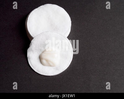 Disque de coton avec de la crème sur fond noir Banque D'Images
