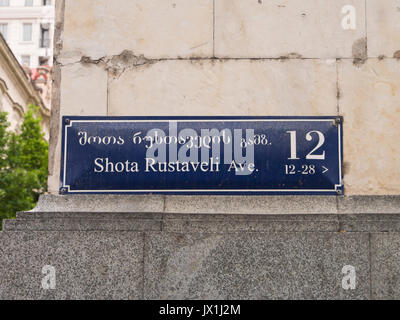 Blue street sign en géorgien et en alphabet latin sur un coin de rue de la Shota Rustaveli Avenue dans le centre de Tbilissi en Géorgie Banque D'Images