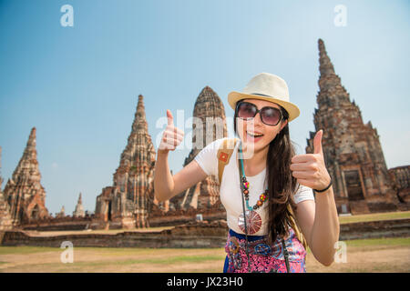 Des étudiants de l'Asie au Wat Chaiwatthanaram fille touristique d'Ayutthaya en Thaïlande la doing Thumbs up hand sign in geste taking photo pendant le voyage Banque D'Images