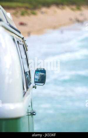 Le miroir de l'aile sur le côté d'un vintage VW Campervan garé avec vue sur la mer. Banque D'Images