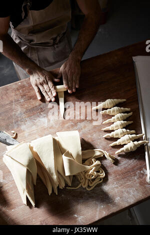 Rouler les croissants français Baker Banque D'Images