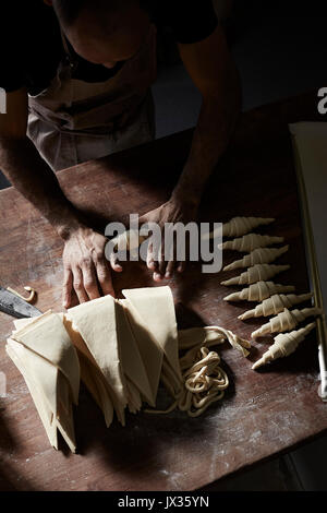 Rouler les croissants français Baker Banque D'Images