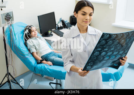 Femme médecin examinant les filles CT scan results Banque D'Images