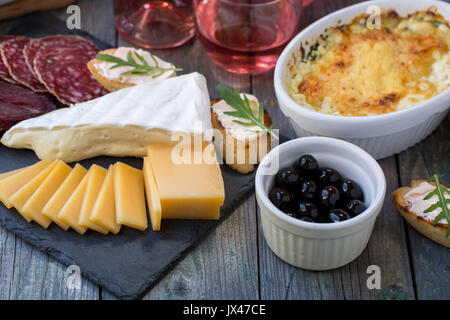 Carte avec basturma, salami, fromage, camembert, d'autres gourmandises et vin rose. Banque D'Images