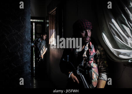 Raqqa, la Syrie. 12Th Aug 2017. Deux soldats armés de la République Les Forces Démocratiques (SDF) par une fenêtre pendant que les batailles contre l'Etat islamique (est) de la milice de terreur continuent à Raqqa, Syrie, 12 août 2017. (Photo disponible oin 14 août 2017.) Photo : Morukc Umnaber/dpa/Alamy Live News Banque D'Images