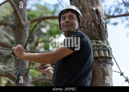 MEZIO, PORTUGAL - 22 juillet 2017 : l'homme aventureux se prépare à une diapositive dans la tyrolienne à travers la forêt. 22 juillet 2017, Mezio, Portugal. Banque D'Images