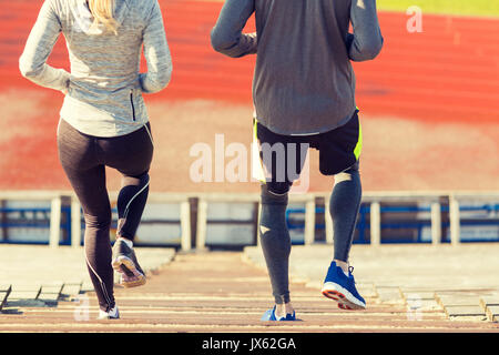 Close up of couple fonctionnant en bas sur stadium Banque D'Images