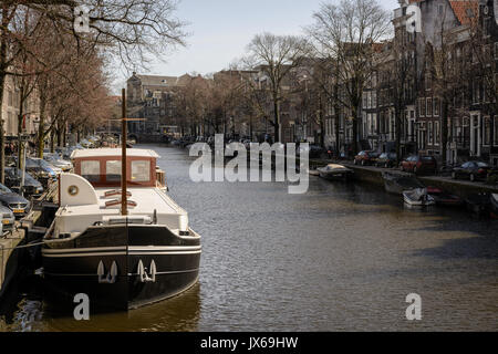 Bateau amarré dans un canal à Amsterdam (Pays-Bas). Mars 2015. Le format paysage. Banque D'Images