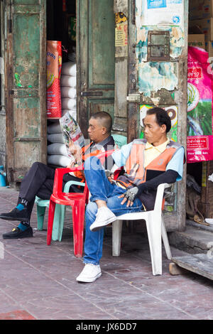 Les chauffeurs de taxi moto assis en attente d'affaires, le quartier chinois, Bangkok, Thaïlande Banque D'Images