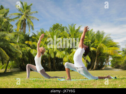 Couple yoga yoga en plein air présentent une fente basse Banque D'Images