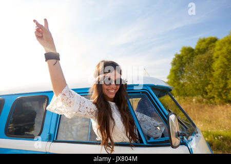 Femme hippie heureux montrant la paix en voiture fourgonnette Banque D'Images