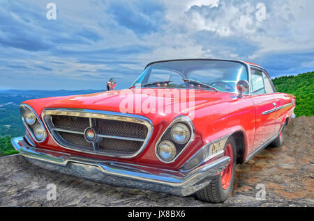 Un rouge vintage Chrysler 300 avec un fond de ciel et les montagnes. Banque D'Images
