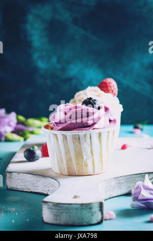 Buttercream cupcakes avec colorés sur une planche à découper. Vue rapprochée, tonique libre Banque D'Images