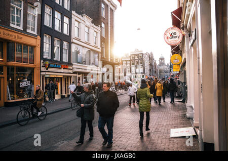 Amsterdam, Pays-Bas - 25 avril, 2017 Tourisme : marcher le long d'une rue étroite de la ville historique d'Amsterdam au coucher du soleil. Banque D'Images